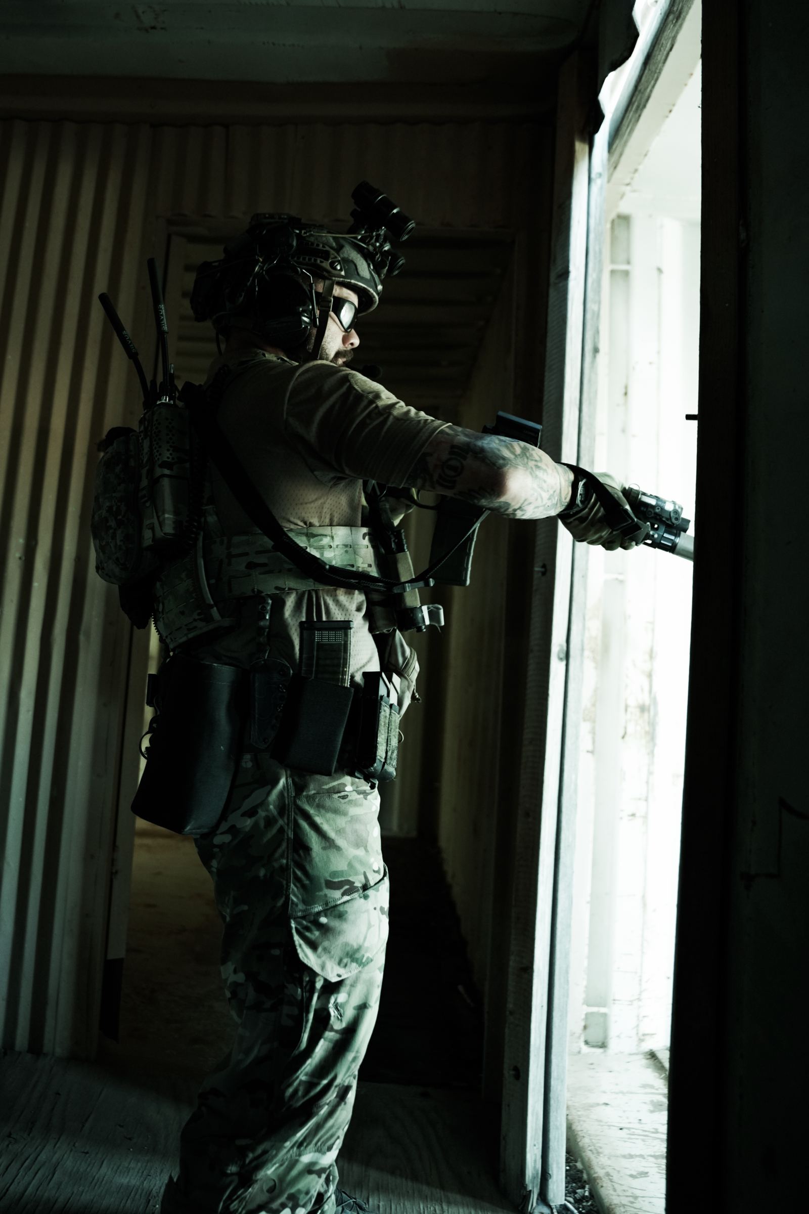 Operator clearing a doorway with a pistol, backlit