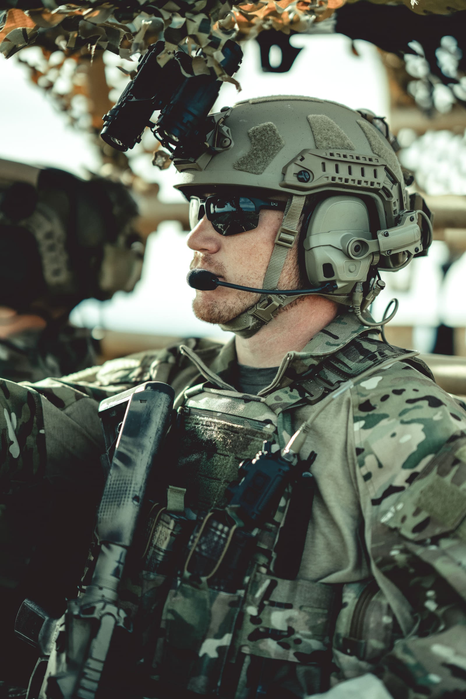 Operator in helmet and headset alongside a vehicle