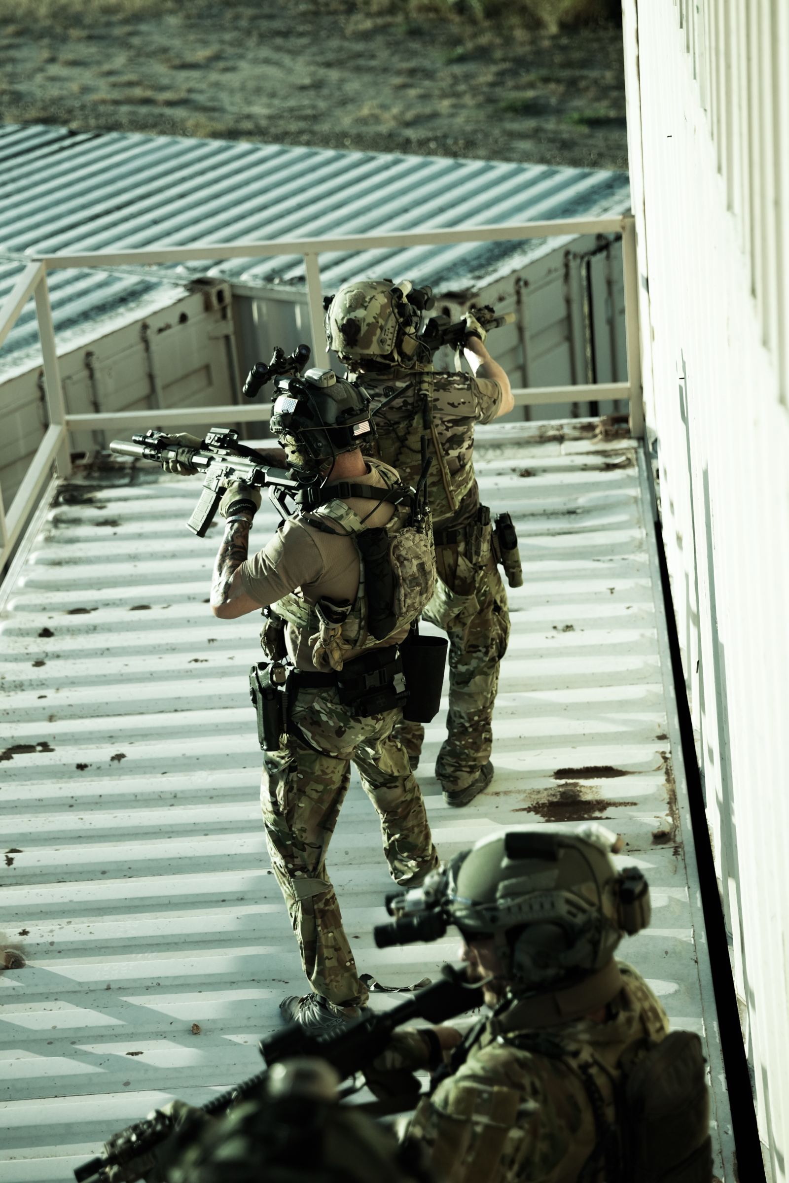 Three operators holding security on a container roof